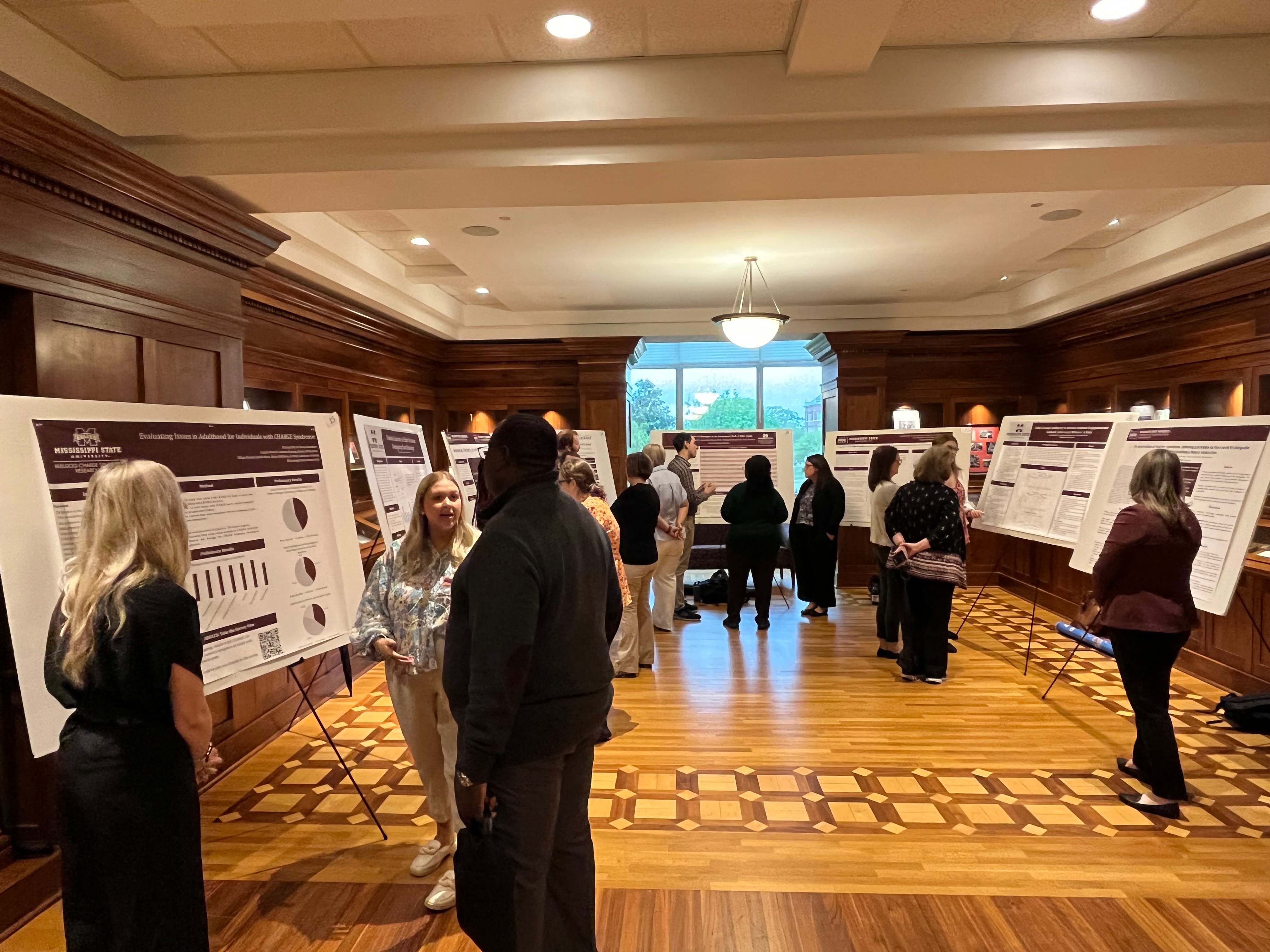 Students present research posters to faculty and staff