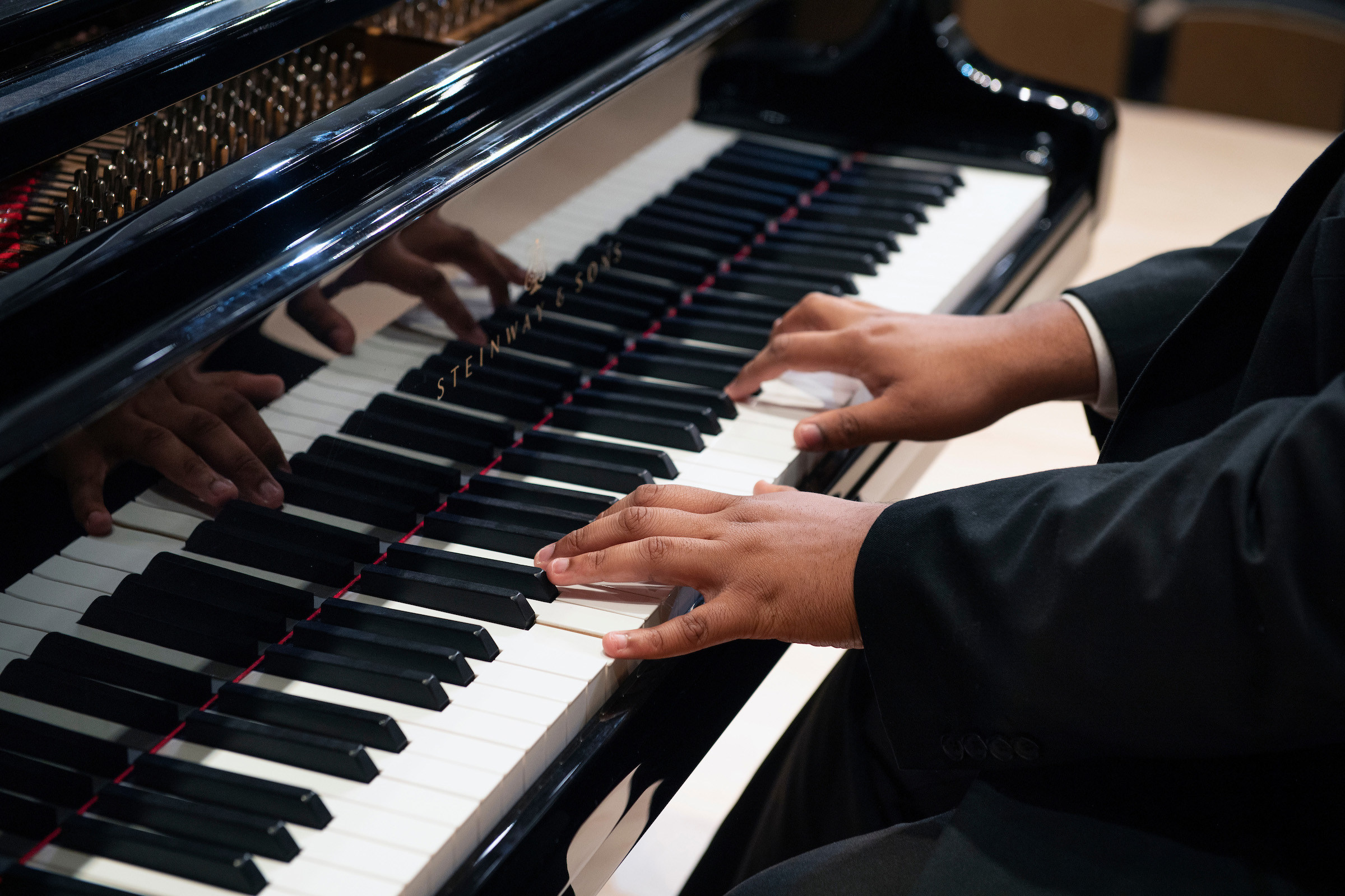 Hands of someone playing a Steinway piano