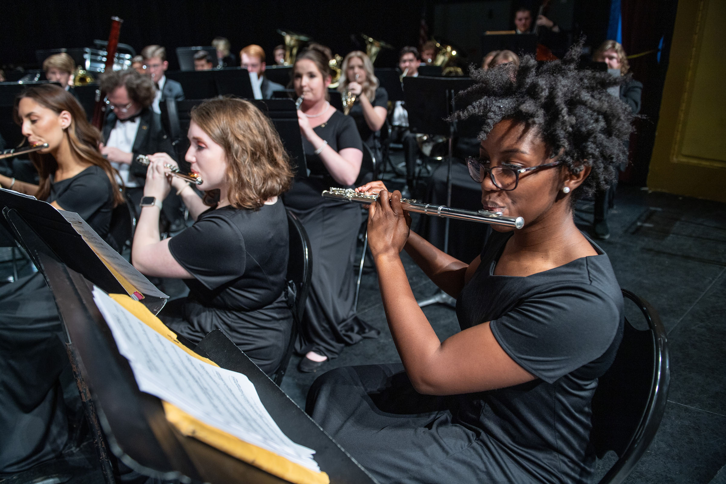 Students performing with instruments in a concert