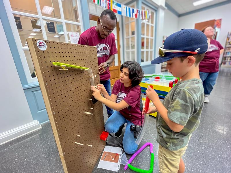 MSU students helping a child with a STEM activity.